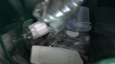 Plastik geri dönüşüm. Kullanılmış plastik şişeler geri dönüşüm kutusuna düşer. Geri dönüşümler ve Ev Atıkları Sıralanıyor