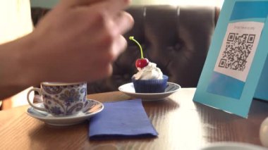 Akıllı telefon alıcıları Qr kodunu tarıyor. Mobil bankacılık. Bir erkek, dükkanlarda, bireysel ürünlerde, web sitesinde veya kağıt faturasında gösterilen kodu tarar.