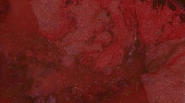 Koyu kırmızı ve Burgundy parlak sıvı kaynıyor. Hareketli Parıltılı Boyalar. Soyut arkaplan