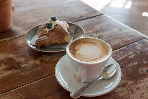 Croissant och en cappuccino för frukost — Stockfoto