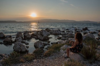 Yalnız kız gün batımını izliyor