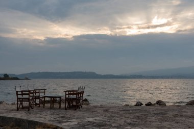 Yunan Denizi kıyısındaki bir restoranın küçük masaları