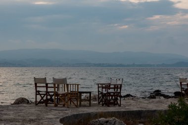 Yunan Denizi kıyısındaki bir restoranın küçük masaları