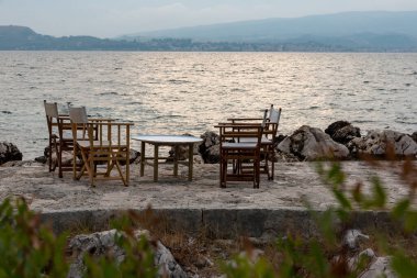 Yunan Denizi kıyısındaki bir restoranın küçük masaları