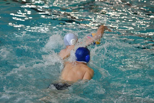 Pojkarna spelar i vattenpolo — Stockfoto