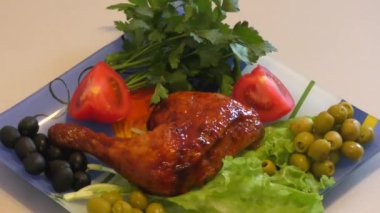 Kızarmış tavuk budu ve öğle yemeği için taze yeşillikler.