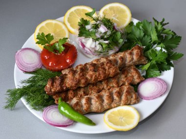 Akdeniz mutfağında taze bitkilerle Lula kebabı.