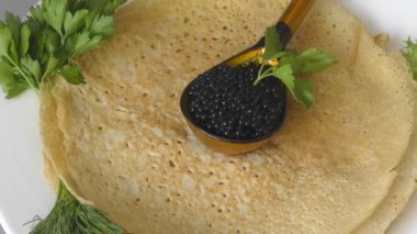 Siyah havyarlı krepler ve taze otlar. 