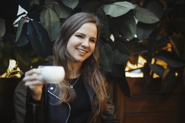 Молодая привлекательная девушка пьет кофе в кафе — стоковое фото