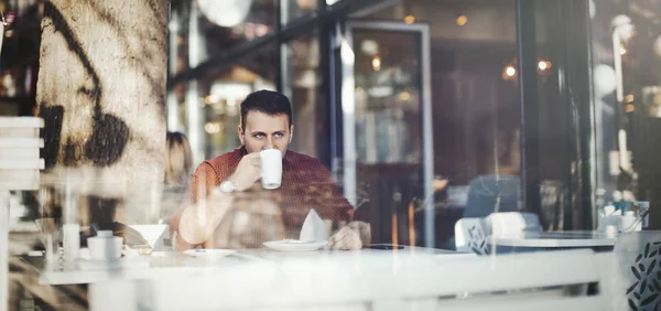 Young attractive man drinking coffee at lunch time