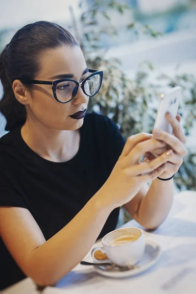 Attraktiva flicka som håller mobiltelefon och SMS meddelande på fika — Stockfoto