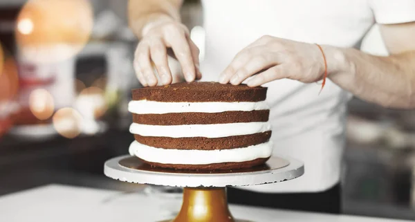 Young attractive man decorating cake — Stock Photo, Image