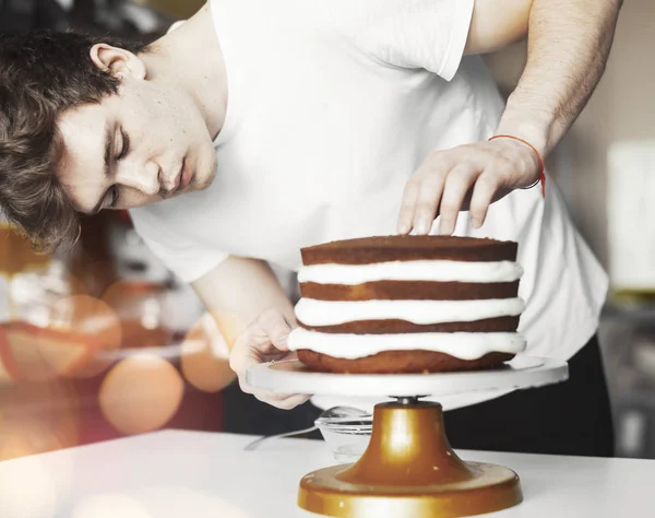 Young attractive man baking cake
