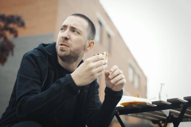 Sakallı adam yeme sandviç Street.