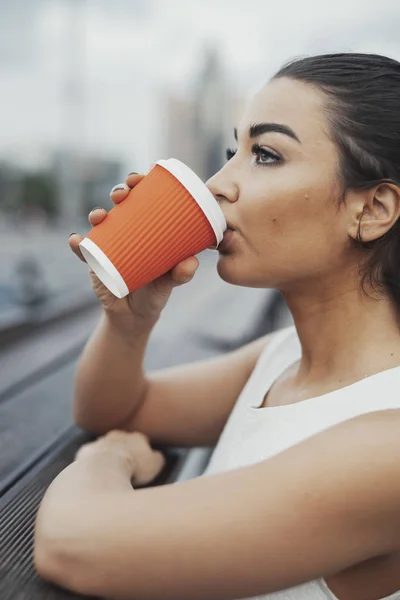 Mujer atractiva joven bebiendo café de la taza roja . — Foto de Stock