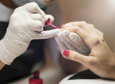 Manikürcü el boyama istemci yakından kırmızı renk çivi.