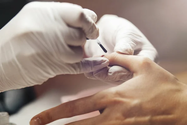 Primer plano de una mujer recibiendo una manicura por un esteticista . — Foto de Stock