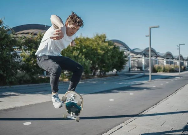 Fiatal, vonzó férfi lovaglás longboard a parkban. — Stock Fotó