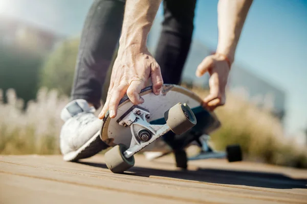 Primer plano del joven atractivo montando longboard en el parque . —  Fotos de Stock