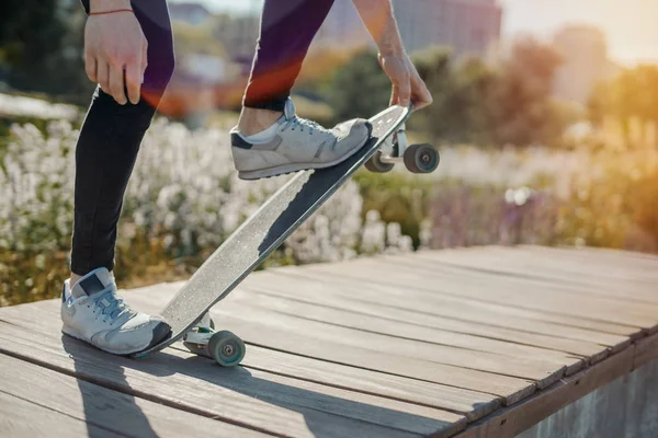 Primer plano del joven atractivo montando longboard en el parque . —  Fotos de Stock