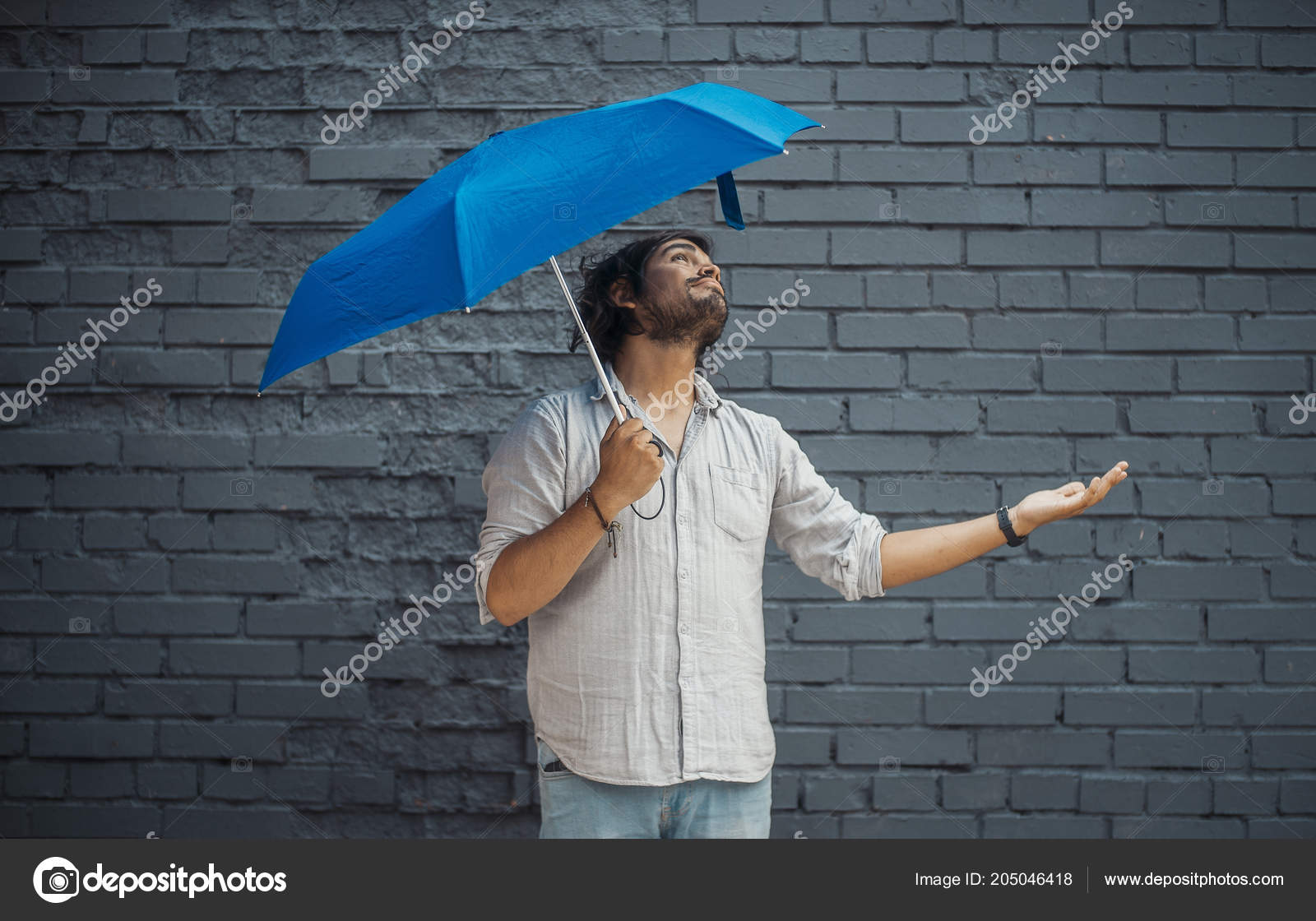 Attractive Brunette Latin Man Holding Blue Umbrella Stretching Out Hand Stock Photo Image By C Akaberka 205046418