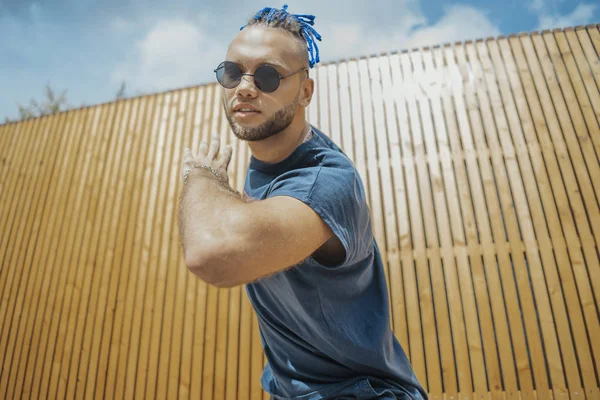 stock image Young man with blue dreadlocks dancing reggaeton in the street.