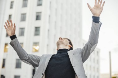 Mutlu adam gülümsüyor ve kollarını için işten geçmeden süre yükselterek yakın çekim.