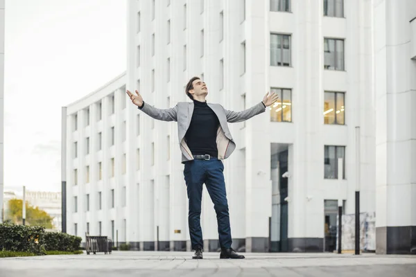 Plano distante de homem feliz levantando os braços enquanto vai para ou do trabalho . — Fotografia de Stock