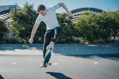 At binme ve longboard parkta atlama genç çekici adam.