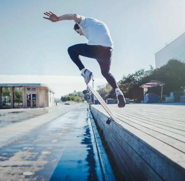 Joven hombre atractivo montar y saltar longboard en el parque . —  Fotos de Stock