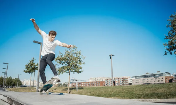 Młody atrakcyjny mężczyzna jazda i skoki longboard w parku. — Zdjęcie stockowe