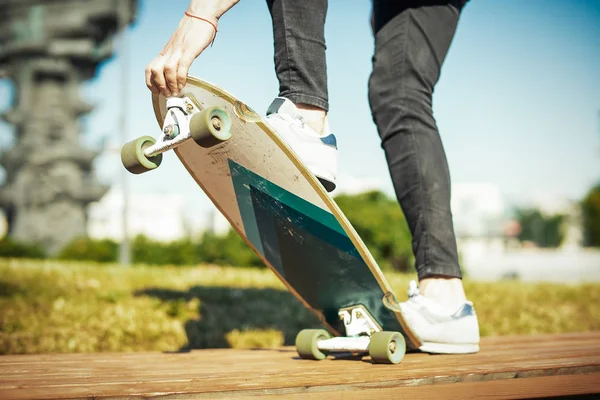 Primo piano del giovane che cavalca longboard o skateboard nel parco . — Foto Stock