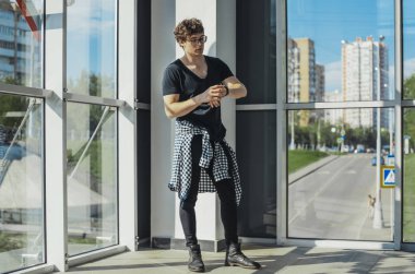 Büyük pencereler yanında duran ve saatler metro istasyonunda bakarak Genç adam.