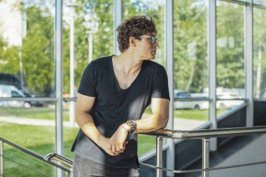 Genç adamın Küpeşte ve windows metro istasyonunun yanında duran yakın çekim.