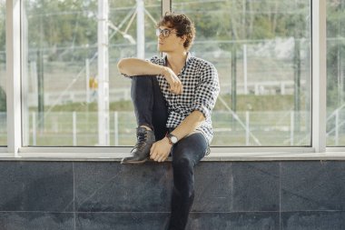 Büyük windows metro istasyonu yanında oturan genç adam uzak planı.