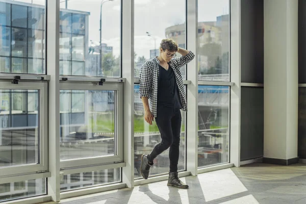 Genç adam büyük windows metro istasyonu yanında ayakta uzak planı.