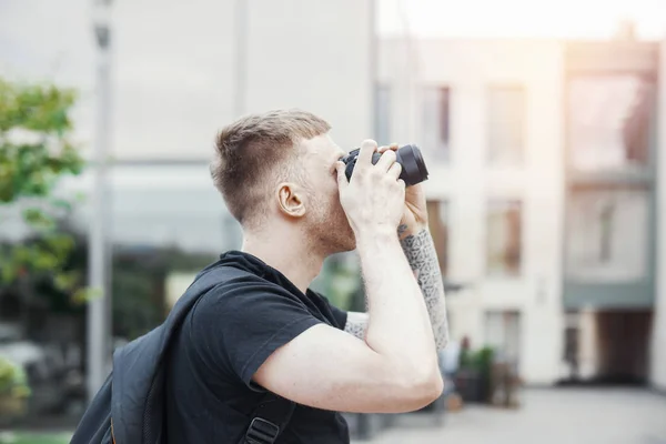 Homem atraente fazendo fotos ao ar livre no fundo da paisagem urbana — Fotografia de Stock