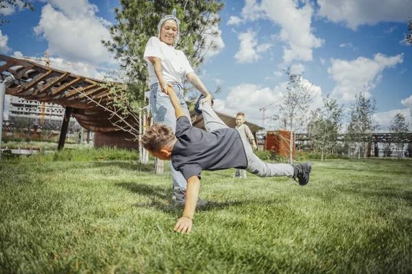 Giovane Mamma Girarsi Vorticoso Divertirsi Con Suoi Figli Parco Verde — Foto Stock