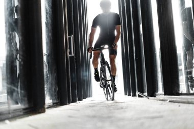 Işık ile kentsel modern cam tünel içinde spor bisiklet kişini. Bisikletçi profesyonel bisiklet eğitim gün. Aktif yaşam tarzı ve açık hobi kavramı.