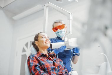 Dişçi x-ray tutan mavi üniformalı süre gülümseyen istemci.