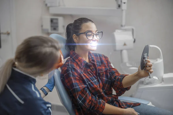 Κοντινό πλάνο Γυναίκα οδοντίατρος και πελάτη νεαρή γυναίκα κρατώντας καθρέφτη και χαμογελάτε. — Φωτογραφία Αρχείου