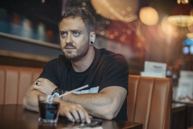 Yemeğini Café için bekleyen genç çekici adam.