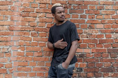 Esmer adamın tuğla zemin üzerine boş siyah T-shirt yakın çekim.