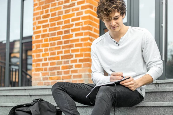 Not etmek onun elinde tutan ve somut adımlar üzerinde oturan çekici adam.