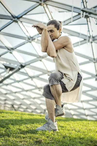 Gros plan d'un homme athlétique attrayant pratiquant le yoga et se réchauffant à l'extérieur . — Photo