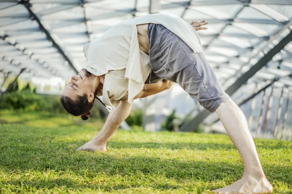 关闭有吸引力的运动男子练习瑜伽和热身户外. — 图库照片