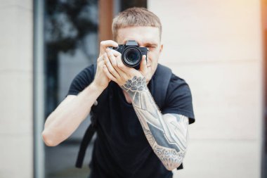 Çekici bir adam fotoğrafçısı fotoğrafları modern binanın yapma yakın çekim.