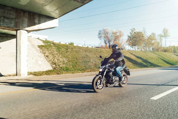 Conductor a caballo motocicleta en camino vacío fuera de la ciudad en el hermoso otoño . —  Fotos de Stock