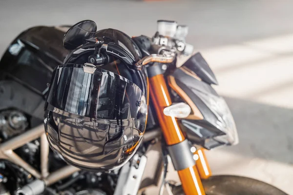 Feche de capacete brilhante preto na motocicleta. Fundo urbano . — Fotografia de Stock