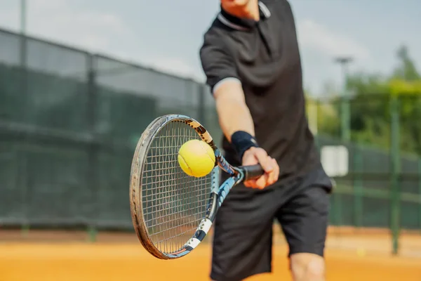 Close up de homem jogando tênis na quadra e batendo a bola com uma raquete . — Fotografia de Stock